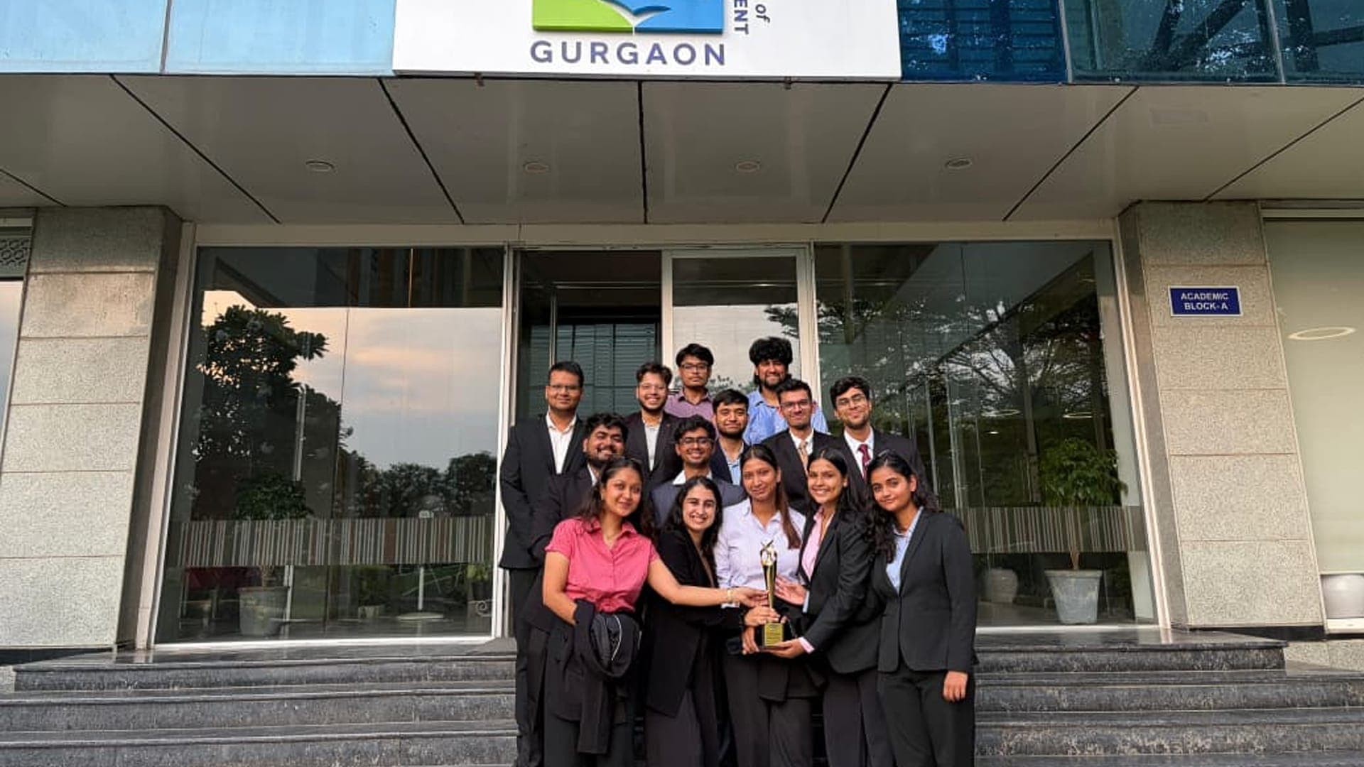Student hackathon team celebrating with its trophy outside Great Lakes Gurgaon