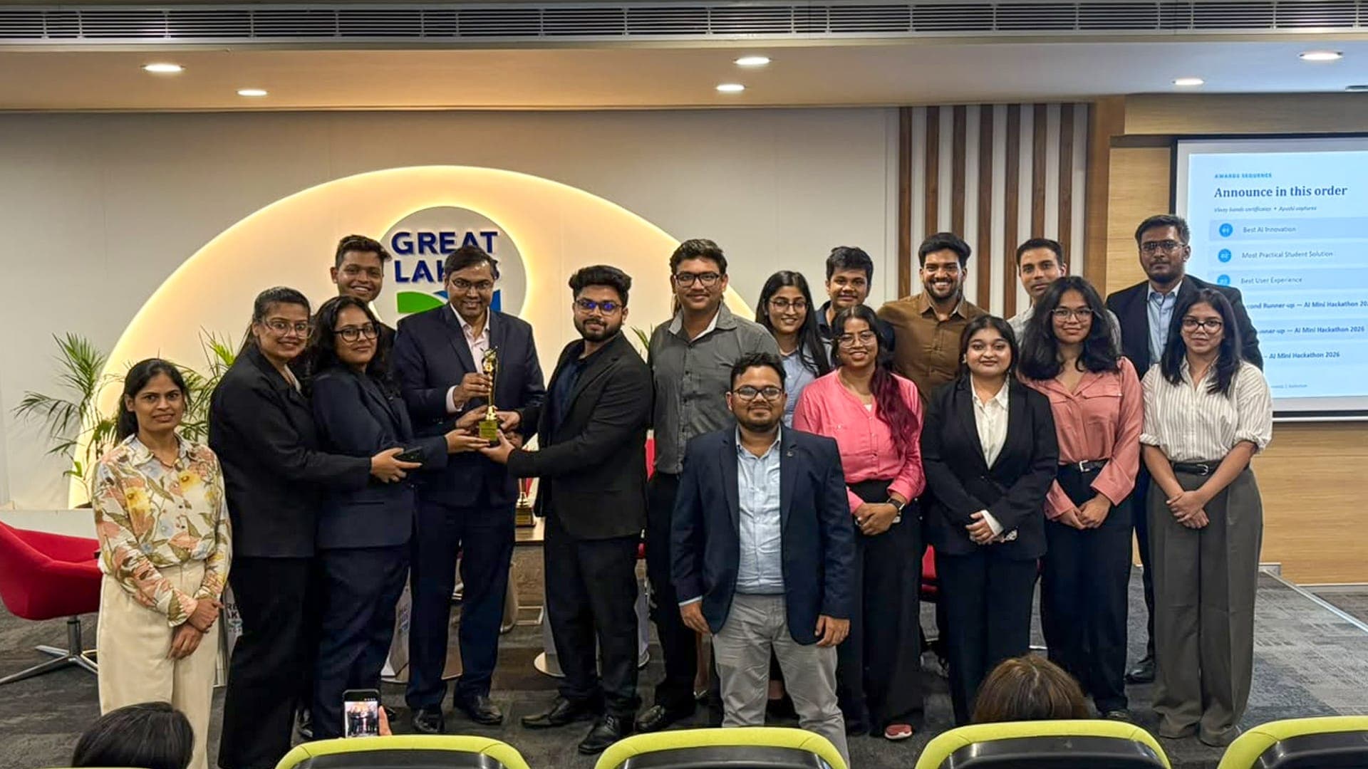Students and faculty gathered around a trophy during the AI Mini Hackathon awards ceremony